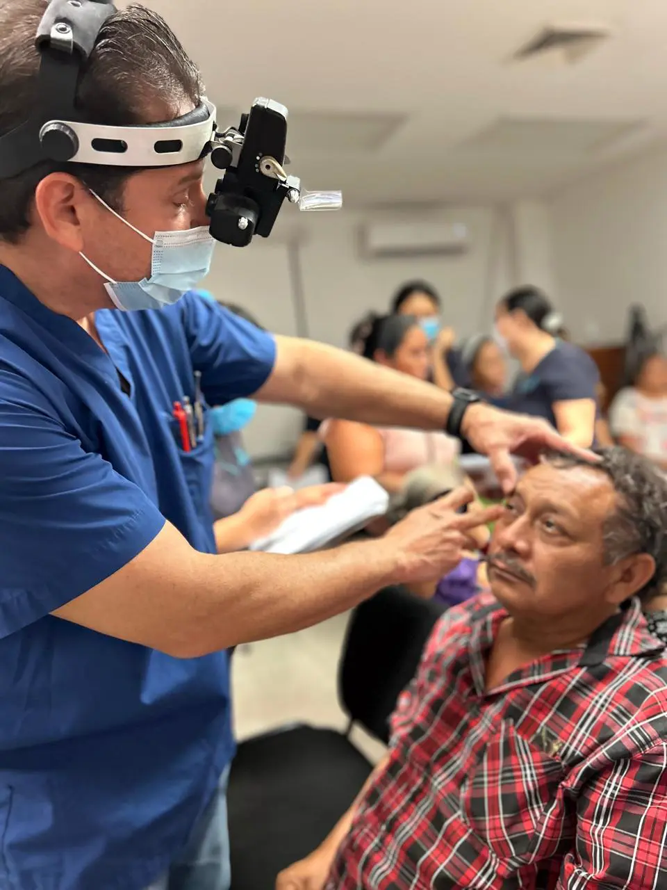 Oftalmólogo examina el ojo de un paciente durante una jornada de RetimediQ